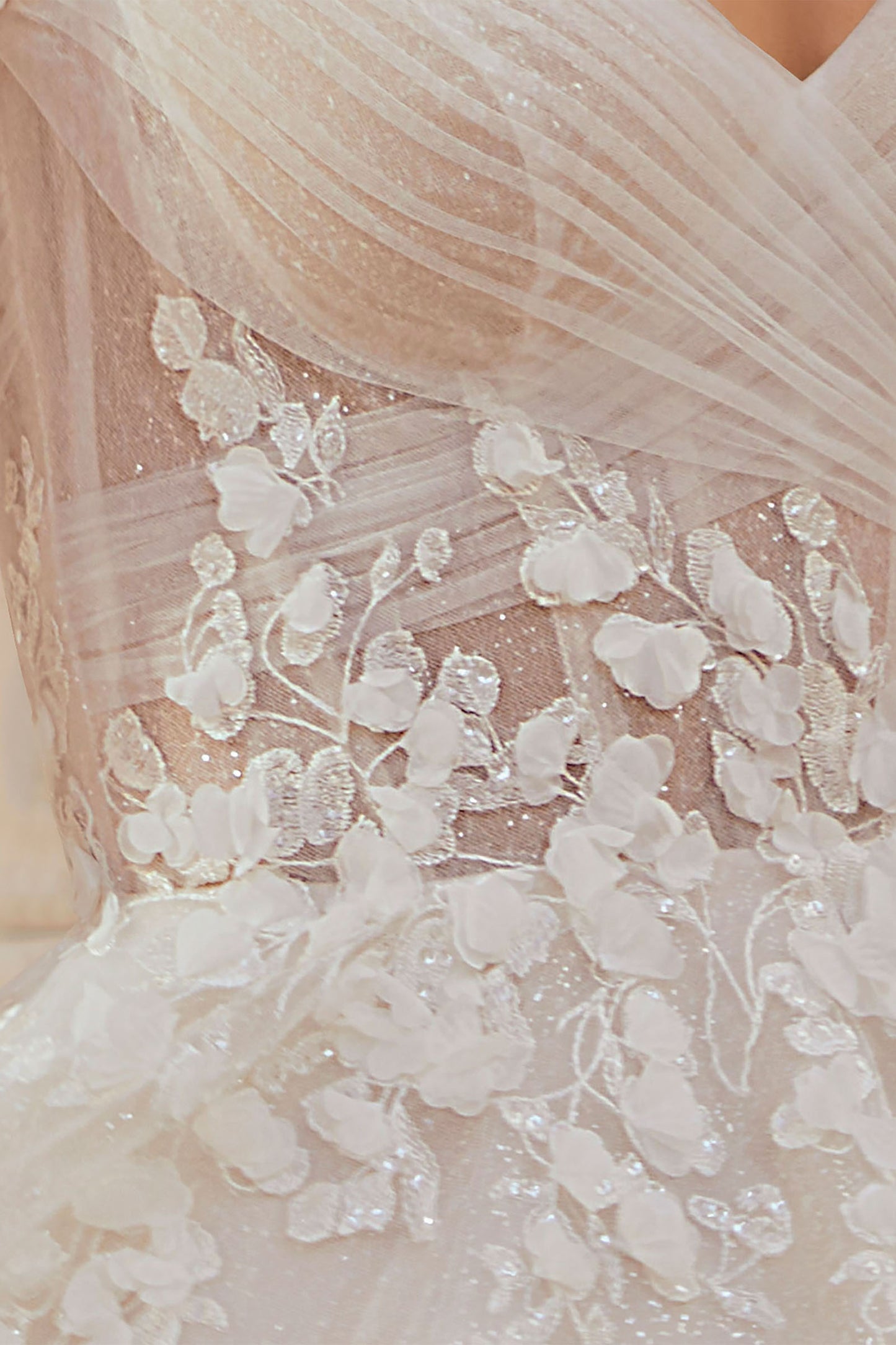 Dreamy ball gown has frosted embroidery with 3D petals and a sheer, draped corset bodice.